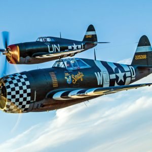 Beautifully restored “razorback” Republic P-47 Thunderbolts owned by The Fighter Collection (foreground) and the Planes of Fame Air Museum fly together.  (© Paul Bowen)